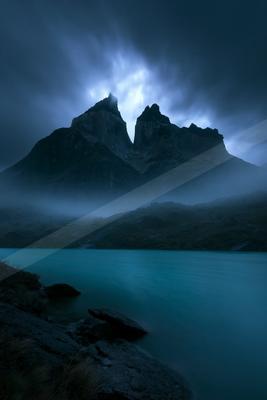 A blue hour long exposure landscape of mountains, storm, fog.