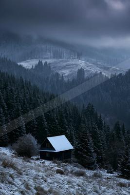 A brown-toned moody photograph of barn, alp, boathouse.