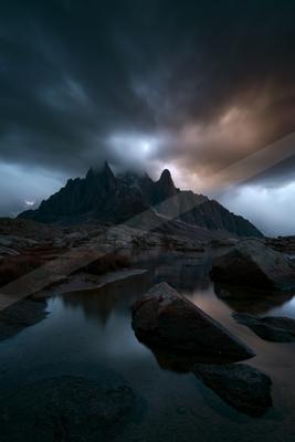 A night landscape of mountains, storm, lake.