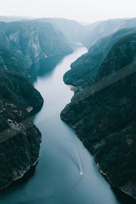 A moody landscape of valley, river, waterfall.