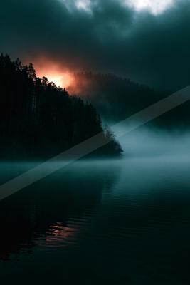 A blue hour long exposure water scene of lake, sunrise, fog.