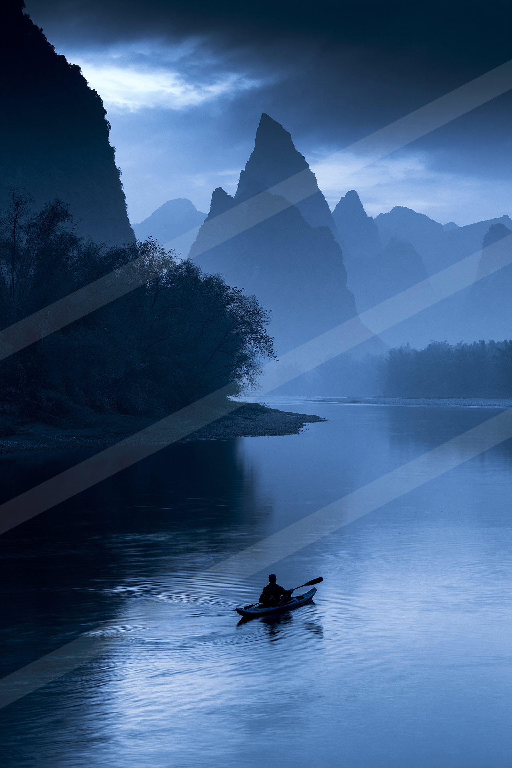 A blue hour water scene of a lake, fog.