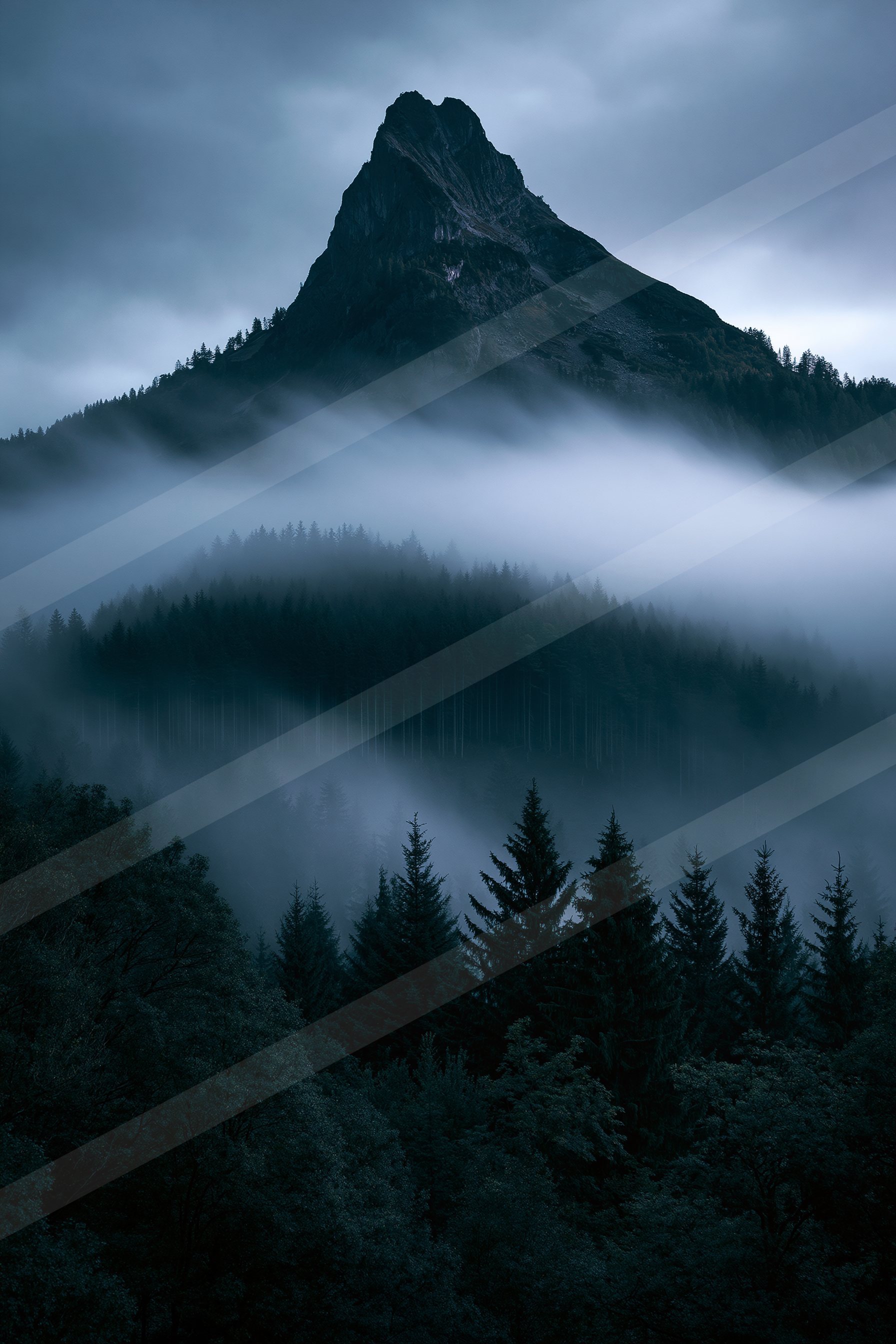 A serene forest landscape shrouded in mist, featuring a towering rocky peak rising above the treeline under a dusky sky.