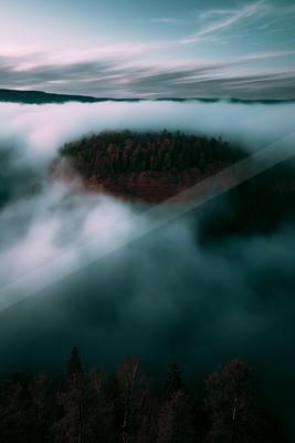 A green-toned moody photograph of volcano, dam, lakeside.