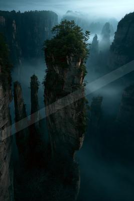 A dramatic landscape of valley, mountains, trees.