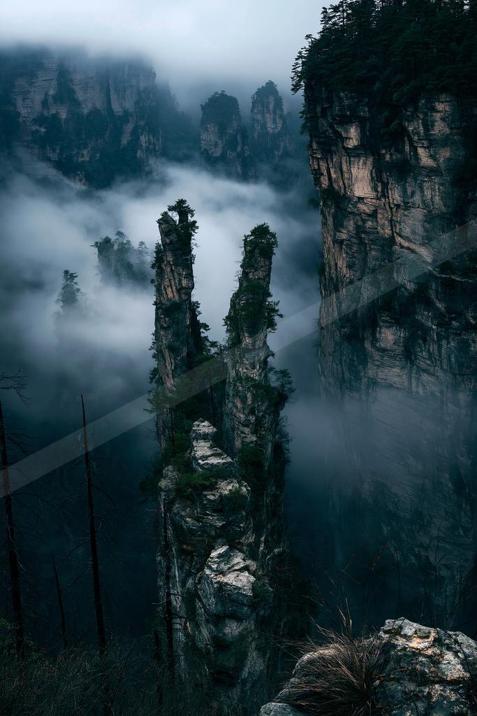 A dramatic landscape of mountains, valley, trees.