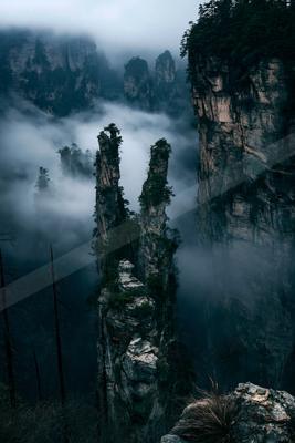 A dramatic landscape of mountains, valley, trees.