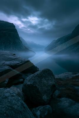 A blue hour long exposure water scene of lake, mountains, river.