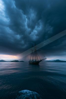 A blue hour sky scene of storm, ocean, clouds.