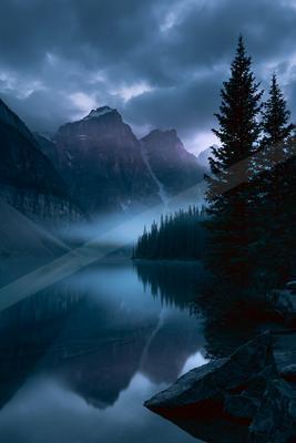 A blue hour landscape of mountains, lake, valley.