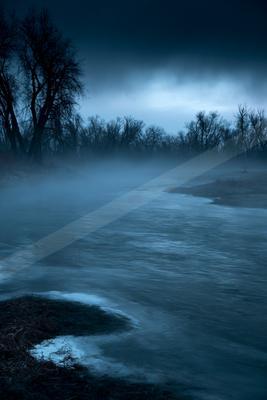 A blue hour long exposure water scene of river, lake, storm.