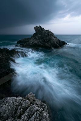 A dramatic long exposure water scene of ocean, storm, rocks.