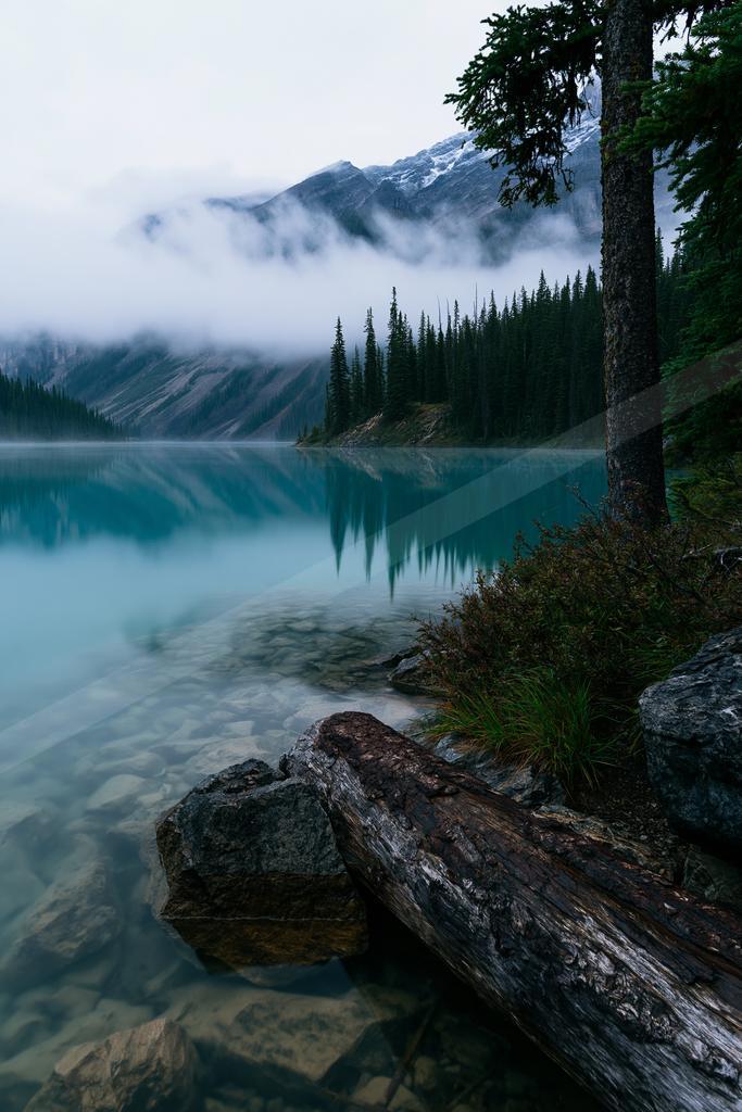 A blue hour water scene of lake, mountains, valley.