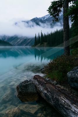 A blue hour water scene of lake, mountains, valley.