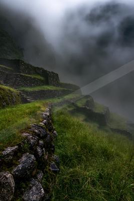 A moody landscape of mountains, valley, fog.