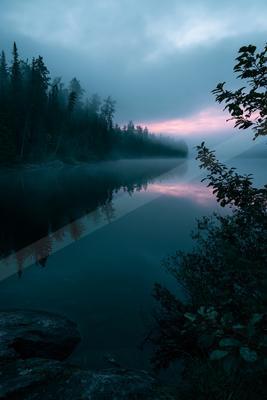 A blue hour water scene of lake, fog.