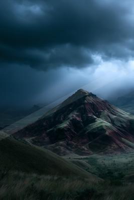 A black-toned moody photograph of volcano, valley, alp.