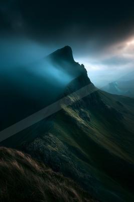 A dark mountain peak emerges from swirling mist under a twilight sky, illuminated by ethereal light.