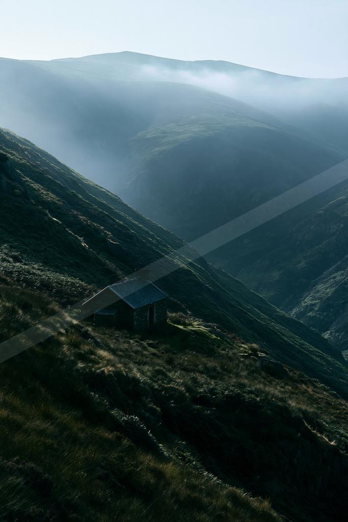 A moody landscape of valley, mountains.