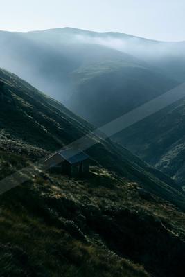 A moody landscape of valley, mountains.