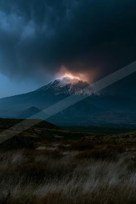 A black-toned moody photograph of volcano, mountain tent, alp.