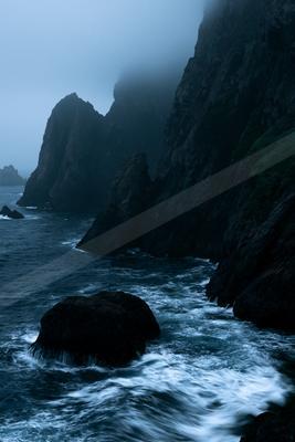 A blue hour long exposure water scene of ocean, storm, fog.