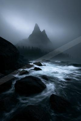 A night landscape of mountains, ocean, waterfall.