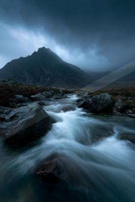 A black-toned moody photograph of valley, volcano, alp.