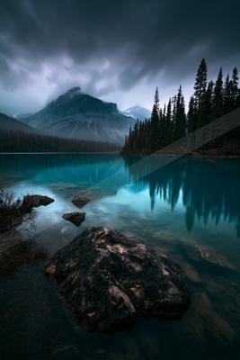 A blue hour water scene of lake, mountains.