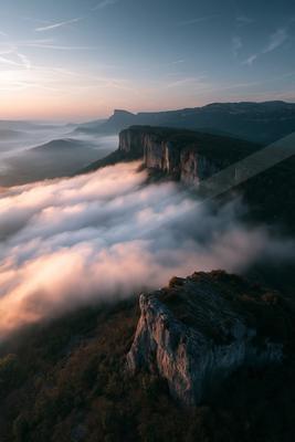 A bright landscape of mountains, valley, clouds.