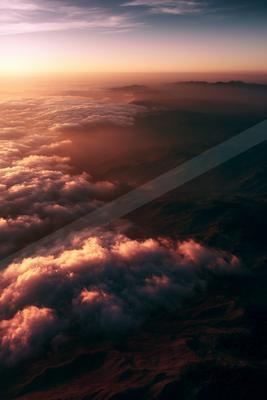 A moody sky scene of clouds, mountains, sunset.