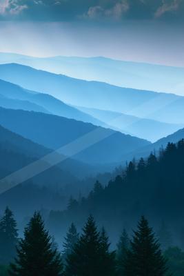 A blue hour high contrast landscape of a mountains, fog.