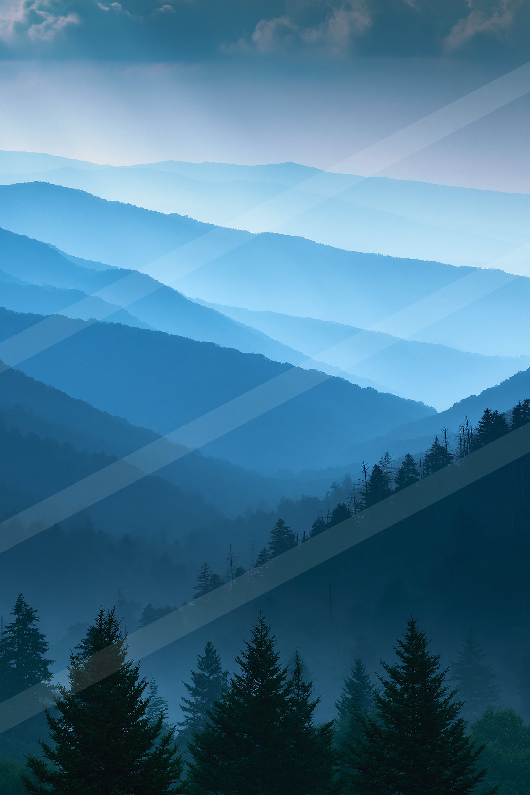 A blue hour high contrast landscape of a mountains, fog.