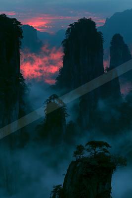 A dramatic landscape of mountains, valley, sunrise.