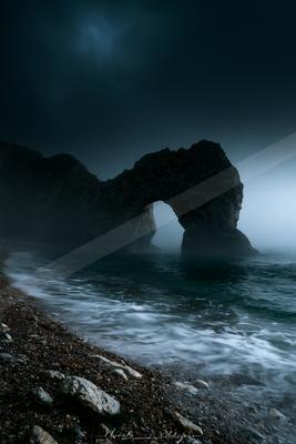 A night water scene of ocean, fog.