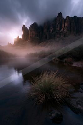 A serene long exposure landscape of mountains, valley, lake.