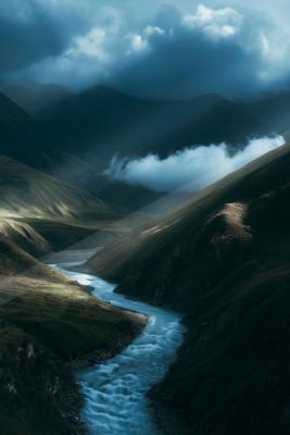 A dramatic long exposure water scene of river, valley, mountains.