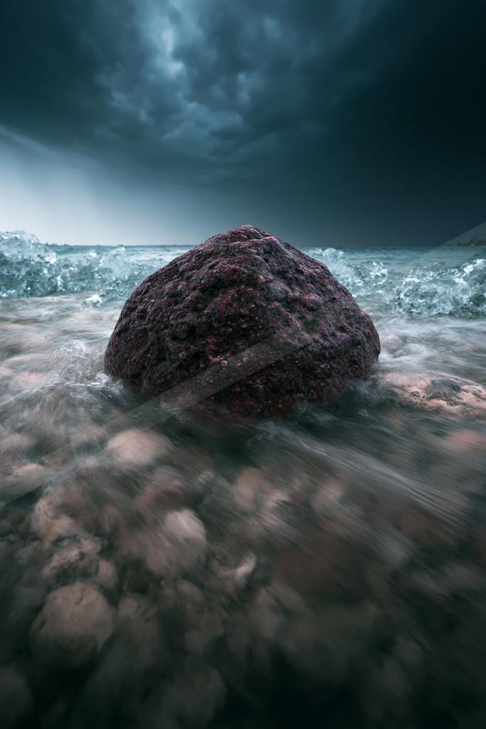 A dramatic long exposure sky scene of storm, ocean, rocks.