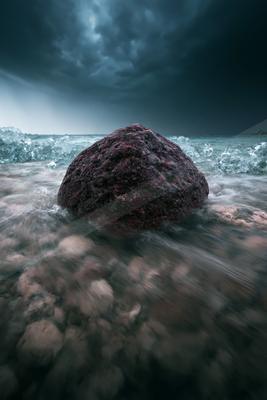 A dramatic long exposure sky scene of storm, ocean, rocks.