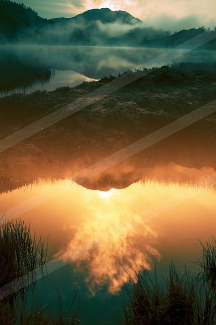 An ethereal double exposure sky scene of a sunrise, reflection.
