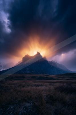 A golden hour landscape of mountains, clouds.