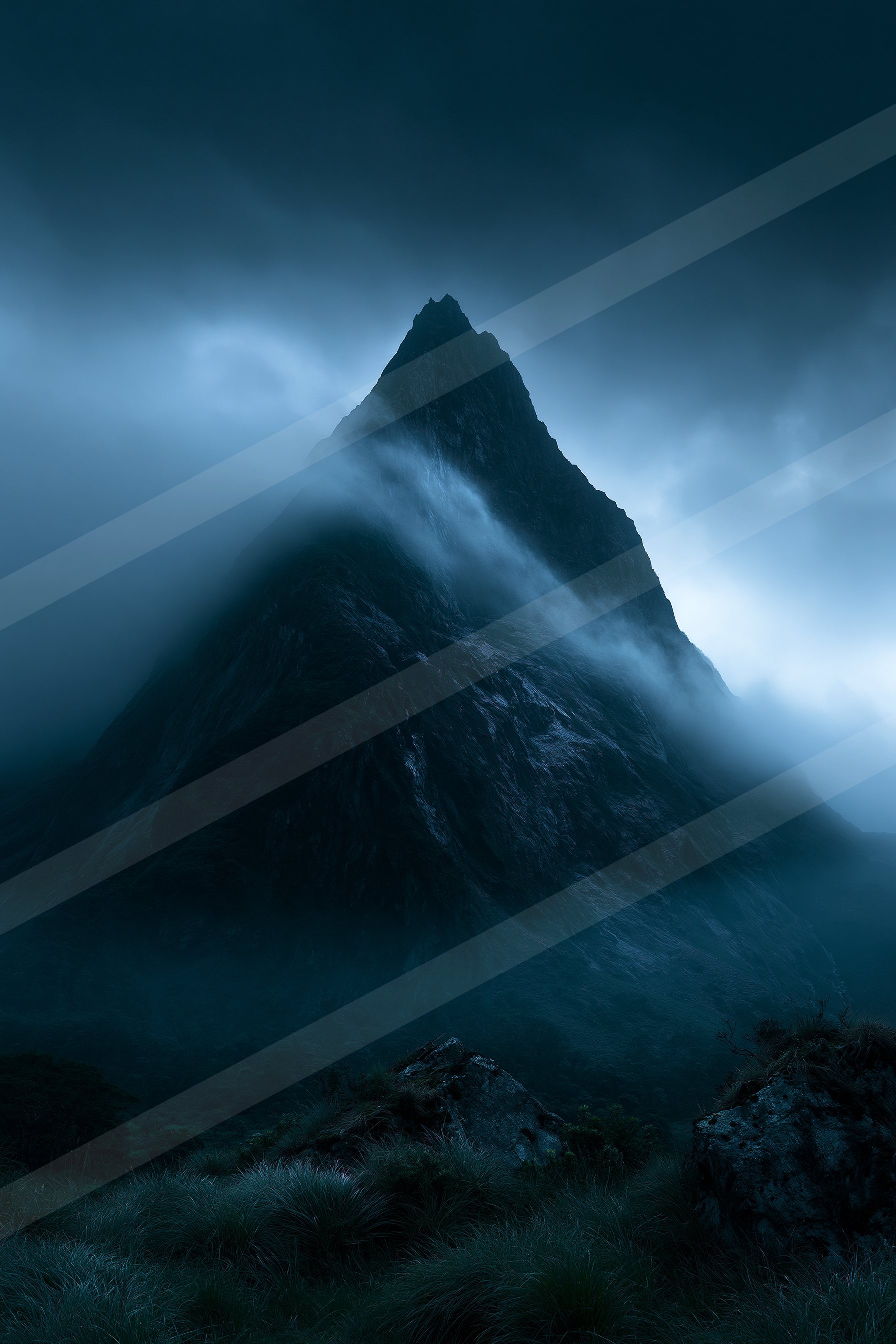 A towering mountain peak shrouded in swirling mist and dark clouds under a night sky.
