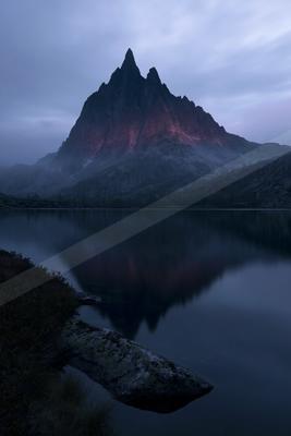 A blue hour landscape of mountains, lake, reflection.