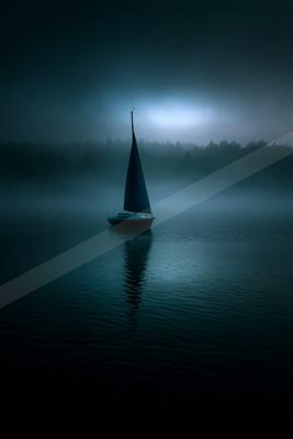 A solitary sailboat with dark sails floats on a calm lake shrouded in dense blue fog, with a forested shoreline barely visible in the background under a dark, m