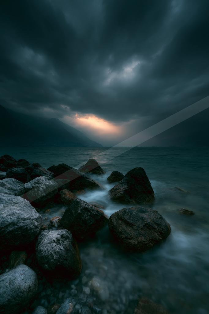 A blue hour long exposure sky scene of storm, ocean, clouds.