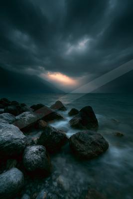 A blue hour long exposure sky scene of storm, ocean, clouds.