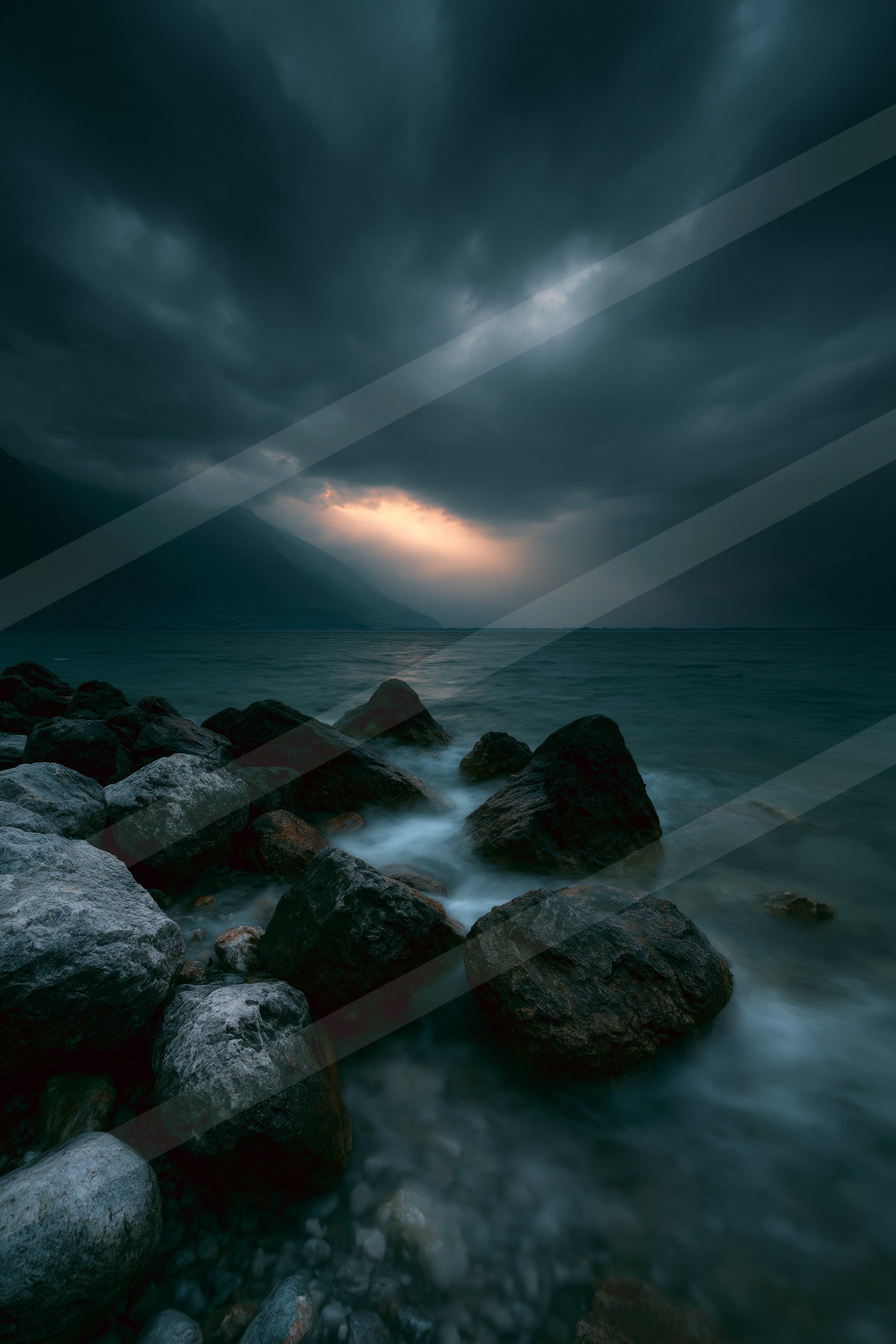 A dramatic long exposure water scene of an ocean, rocks.