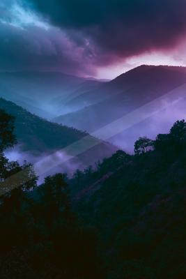 A moody landscape of mountains, valley.