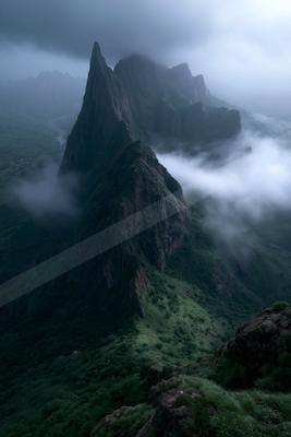 A moody landscape of mountains, valley, fog.