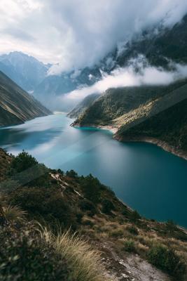 A gray-toned moody photograph of valley, lakeside, alp.
